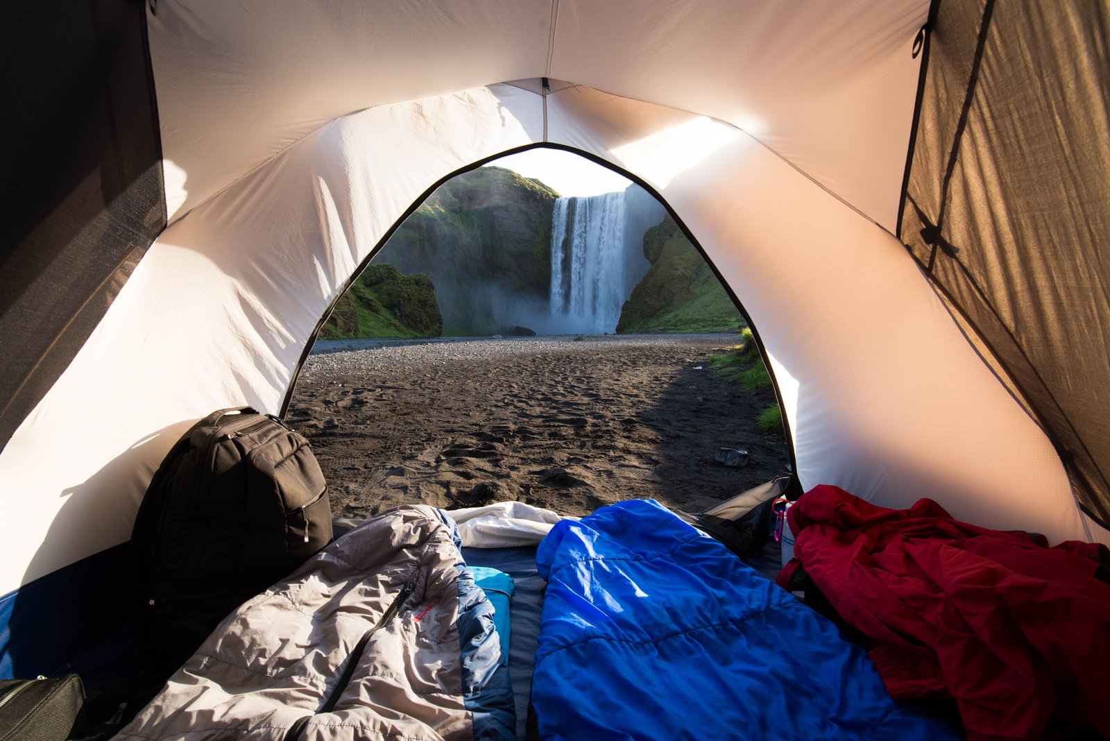 A waterfall view from inside a tent